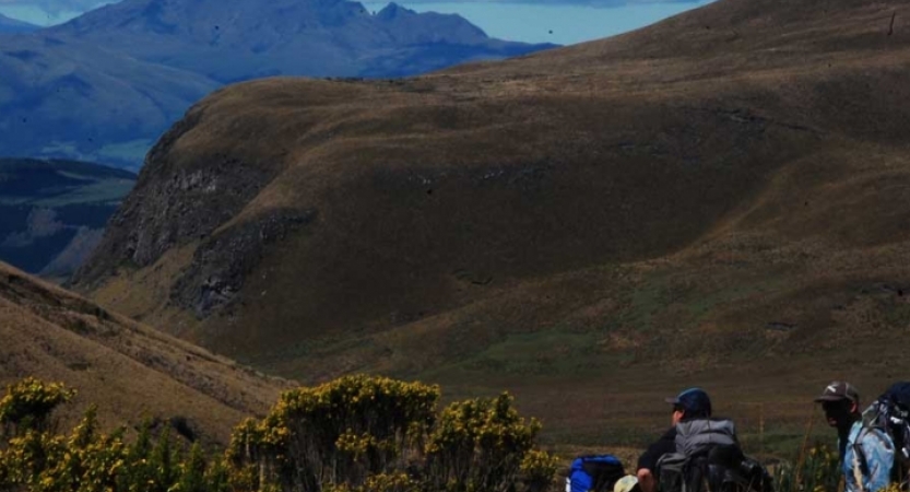 Students stand before a vast mountainous landscape